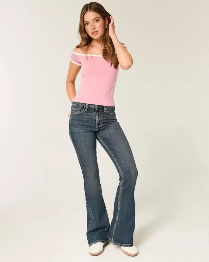 Hoch geschnittene Schlagjeans mit dunkler Waschung und Blumenstickerei Hoch geschnittene Schlagjeans mit dunkler Waschung und Blumenstickerei