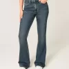 Hoch geschnittene Schlagjeans mit dunkler Waschung und Blumenstickerei Hoch geschnittene Schlagjeans mit dunkler Waschung und Blumenstickerei