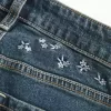 Hoch geschnittene Schlagjeans mit dunkler Waschung und Blumenstickerei Hoch geschnittene Schlagjeans mit dunkler Waschung und Blumenstickerei