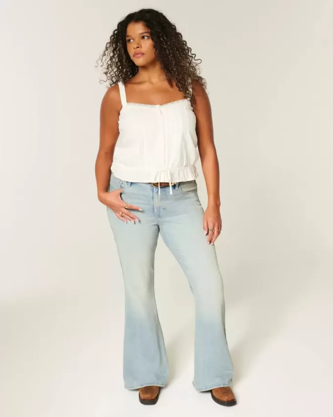 Hoch geschnittene Schlagjeans mit heller Waschung und Sterntaschen Hoch geschnittene Schlagjeans mit heller Waschung und Sterntaschen