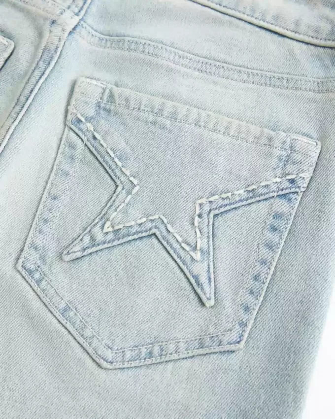 Hoch geschnittene Schlagjeans mit heller Waschung und Sterntaschen Hoch geschnittene Schlagjeans mit heller Waschung und Sterntaschen