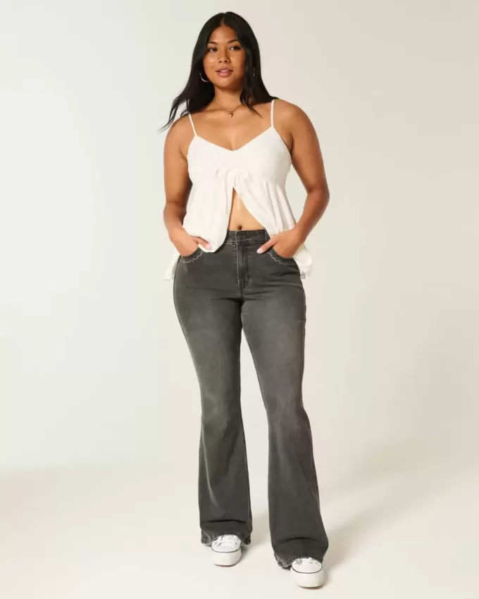 Hoch geschnittene, verwaschene, schwarze Schlagjeans mit Stickerei Hoch geschnittene, verwaschene, schwarze Schlagjeans mit Stickerei