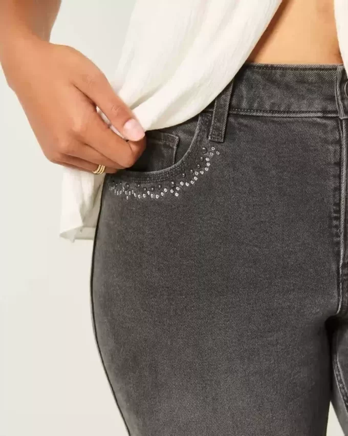 Hoch geschnittene, verwaschene, schwarze Schlagjeans mit Stickerei Hoch geschnittene, verwaschene, schwarze Schlagjeans mit Stickerei