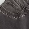 Hoch geschnittene, verwaschene, schwarze Schlagjeans mit Stickerei Hoch geschnittene, verwaschene, schwarze Schlagjeans mit Stickerei