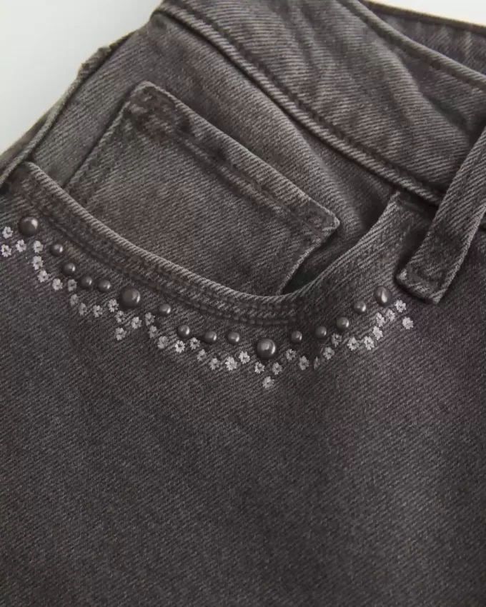 Hoch geschnittene, verwaschene, schwarze Schlagjeans mit Stickerei Hoch geschnittene, verwaschene, schwarze Schlagjeans mit Stickerei