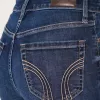 Hoch geschnittene, zerrissene Schlagjeans in dunkler Waschung Hoch geschnittene, zerrissene Schlagjeans in dunkler Waschung