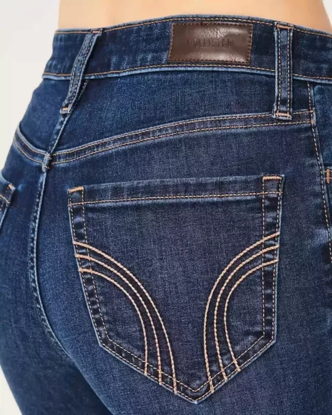 Hoch geschnittene, zerrissene Schlagjeans in dunkler Waschung Hoch geschnittene, zerrissene Schlagjeans in dunkler Waschung