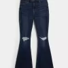 Hoch geschnittene, zerrissene Schlagjeans in dunkler Waschung Hoch geschnittene, zerrissene Schlagjeans in dunkler Waschung