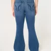 Hoch geschnittene, zerrissene Schlagjeans in mittlerer Waschung Hoch geschnittene, zerrissene Schlagjeans in mittlerer Waschung