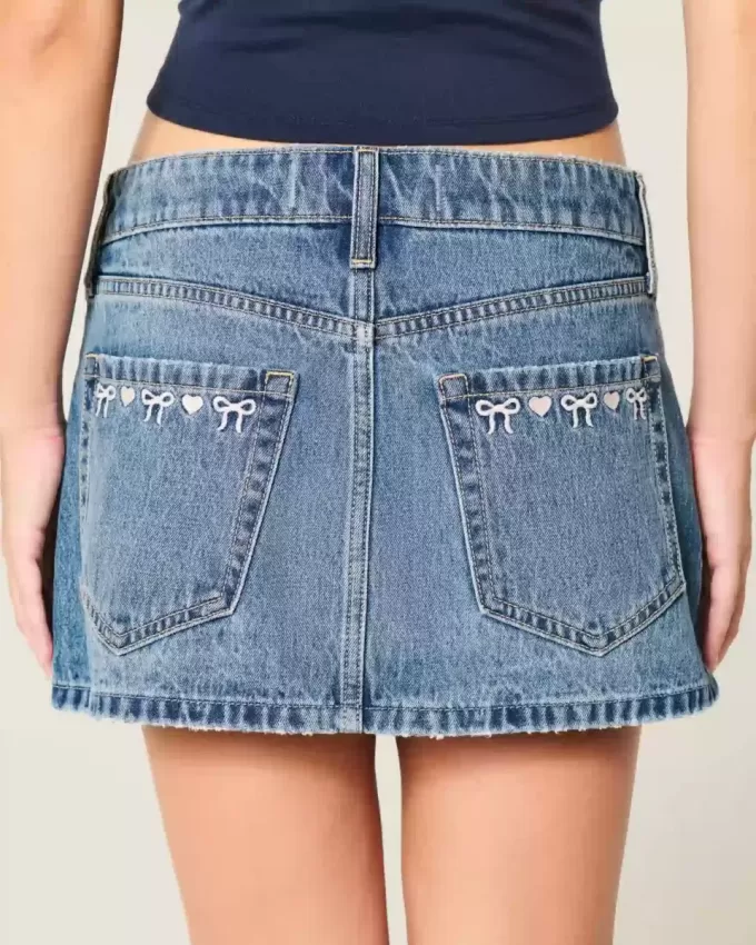 Low-Rise-Mini-Jeansrock mit bestickter Schleife Low-Rise-Mini-Jeansrock mit bestickter Schleife