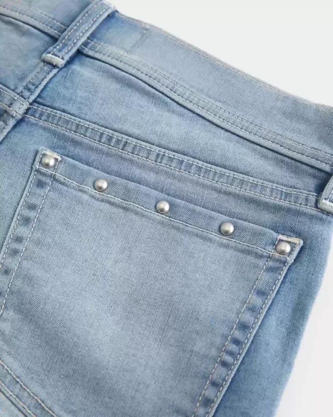 Low-Rise-Shortie-Shorts aus Denim mit mittlerer Waschung und Nieten Low-Rise-Shortie-Shorts aus Denim mit mittlerer Waschung und Nieten