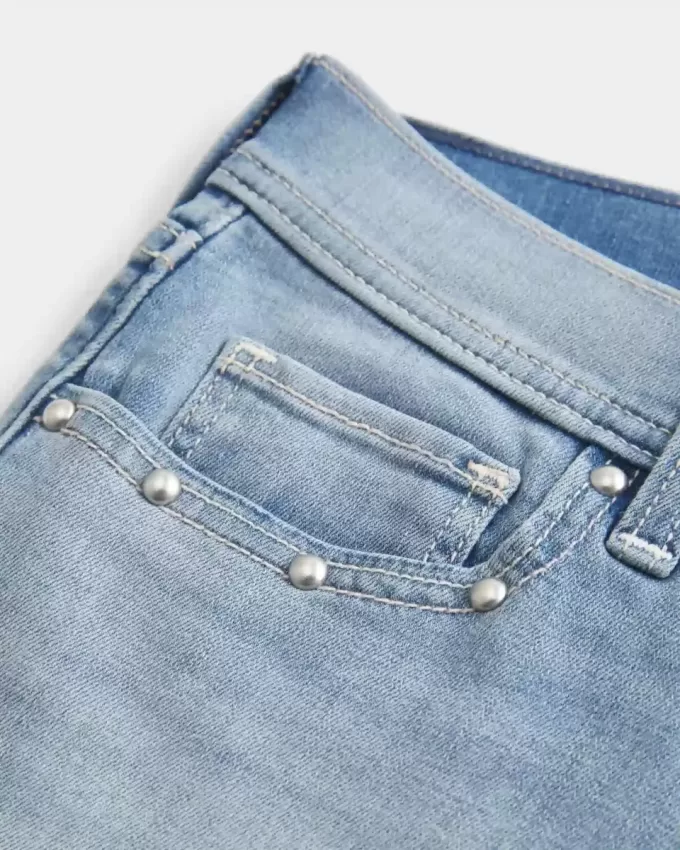 Low-Rise-Shortie-Shorts aus Denim mit mittlerer Waschung und Nieten Low-Rise-Shortie-Shorts aus Denim mit mittlerer Waschung und Nieten