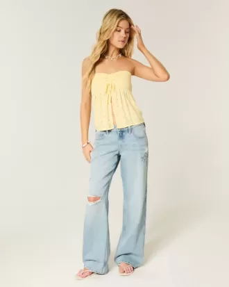 Niedrig geschnittene Baggy-Jeans mit Rissen und heller Waschung und Grafik