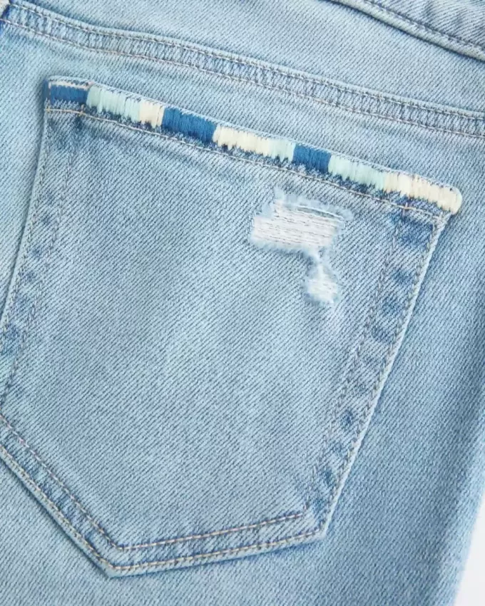 Niedrig geschnittene, zerrissene Bootcut-Jeans in heller Waschung mit Stickerei Niedrig geschnittene, zerrissene Bootcut-Jeans in heller Waschung mit Stickerei