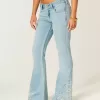 Ultra Low Rise Schlagjeans mit heller Waschung und Blumenstickerei Ultra Low Rise Schlagjeans mit heller Waschung und Blumenstickerei