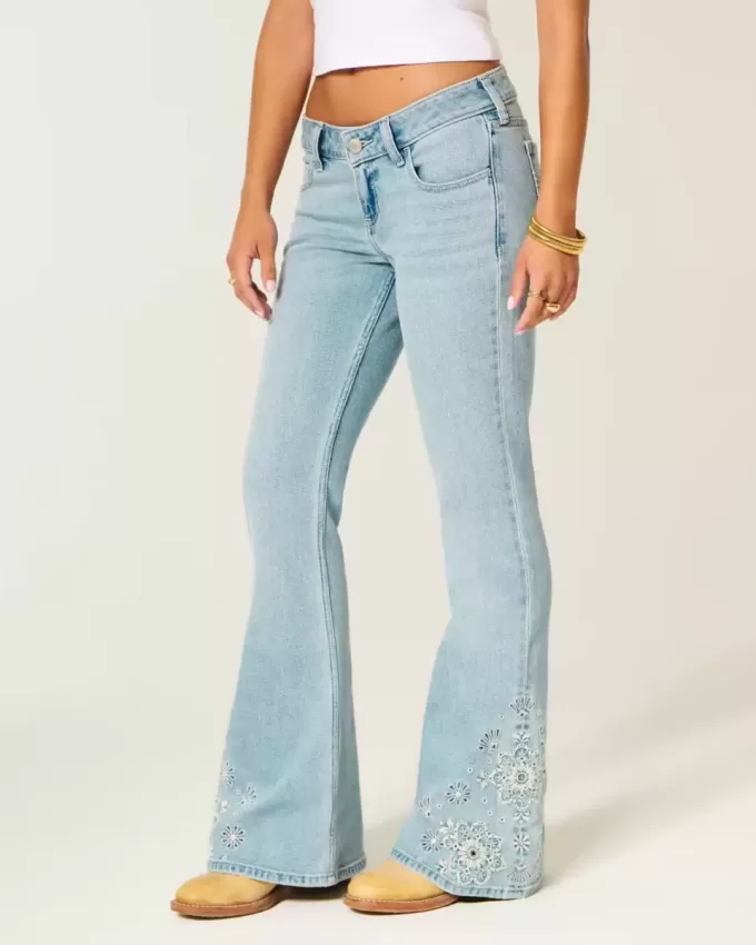 Ultra Low Rise Schlagjeans mit heller Waschung und Blumenstickerei Ultra Low Rise Schlagjeans mit heller Waschung und Blumenstickerei