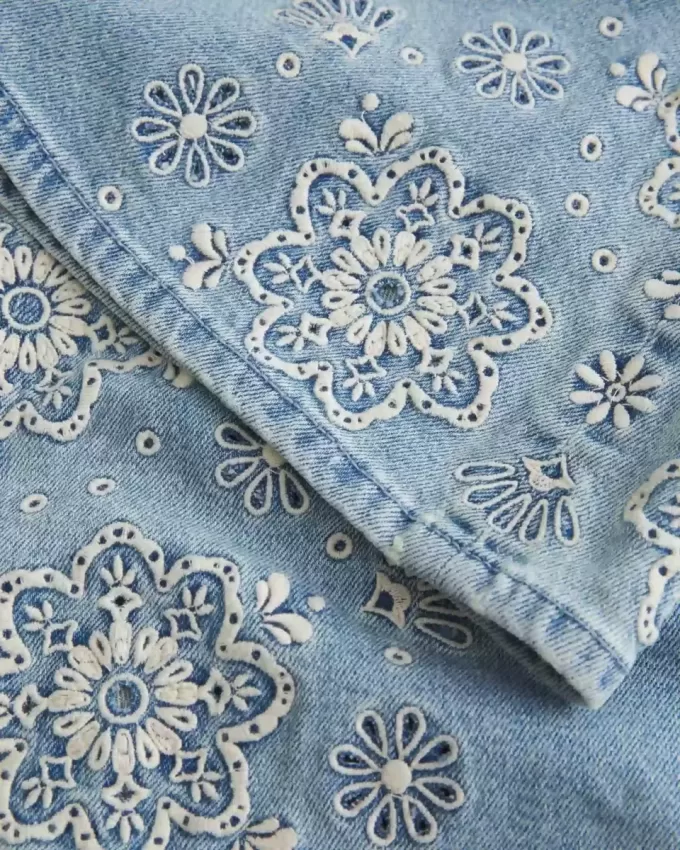Ultra Low Rise Schlagjeans mit heller Waschung und Blumenstickerei Ultra Low Rise Schlagjeans mit heller Waschung und Blumenstickerei