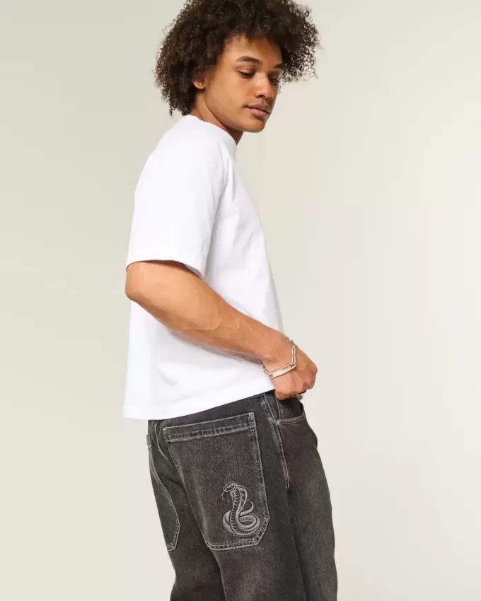 Verwaschene schwarze Skater-Baggy-Jeans mit Schlangenstickerei Verwaschene schwarze Skater-Baggy-Jeans mit Schlangenstickerei