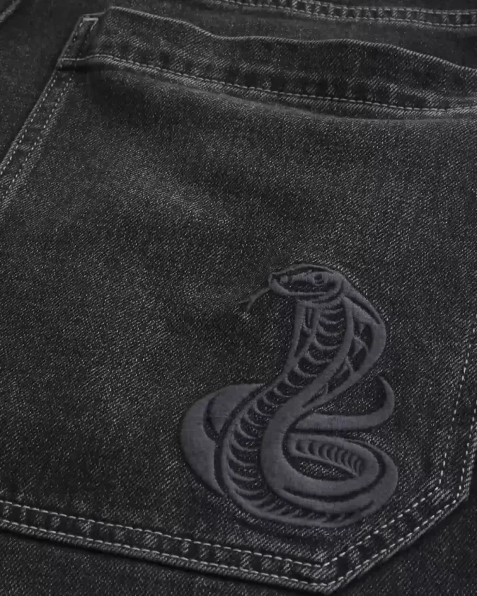 Verwaschene schwarze Skater-Baggy-Jeans mit Schlangenstickerei Verwaschene schwarze Skater-Baggy-Jeans mit Schlangenstickerei